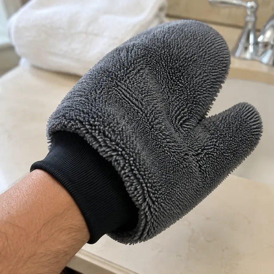 Hand wearing the GloveIt mitt at the bathroom vanity